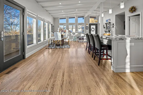 a view of a dining room and livingroom with furniture wooden floor a chandelier