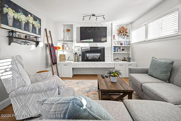 a living room with furniture a flat screen tv and a fireplace