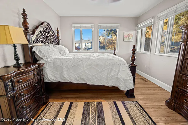a bedroom with a bed and wooden floor