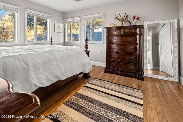 a bed sitting in a bedroom next to a window with dresser