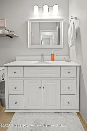 a bathroom with a sink vanity and mirror