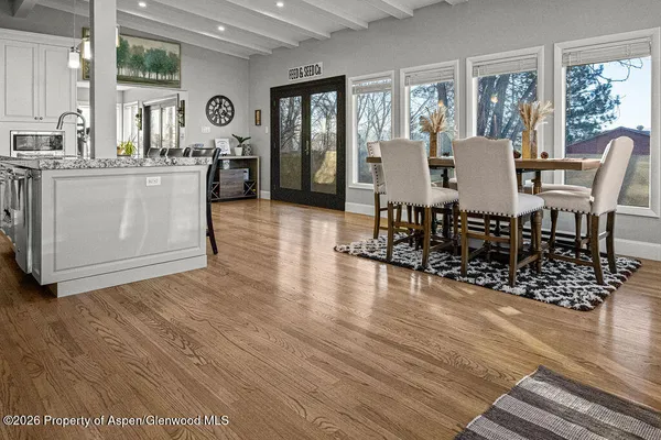 a large white kitchen with wooden floor
