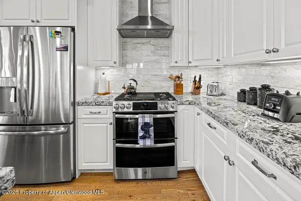 a kitchen with stainless steel appliances granite countertop a stove and a refrigerator