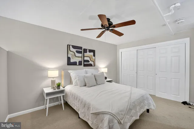 a bedroom with a bed and painting on the wall
