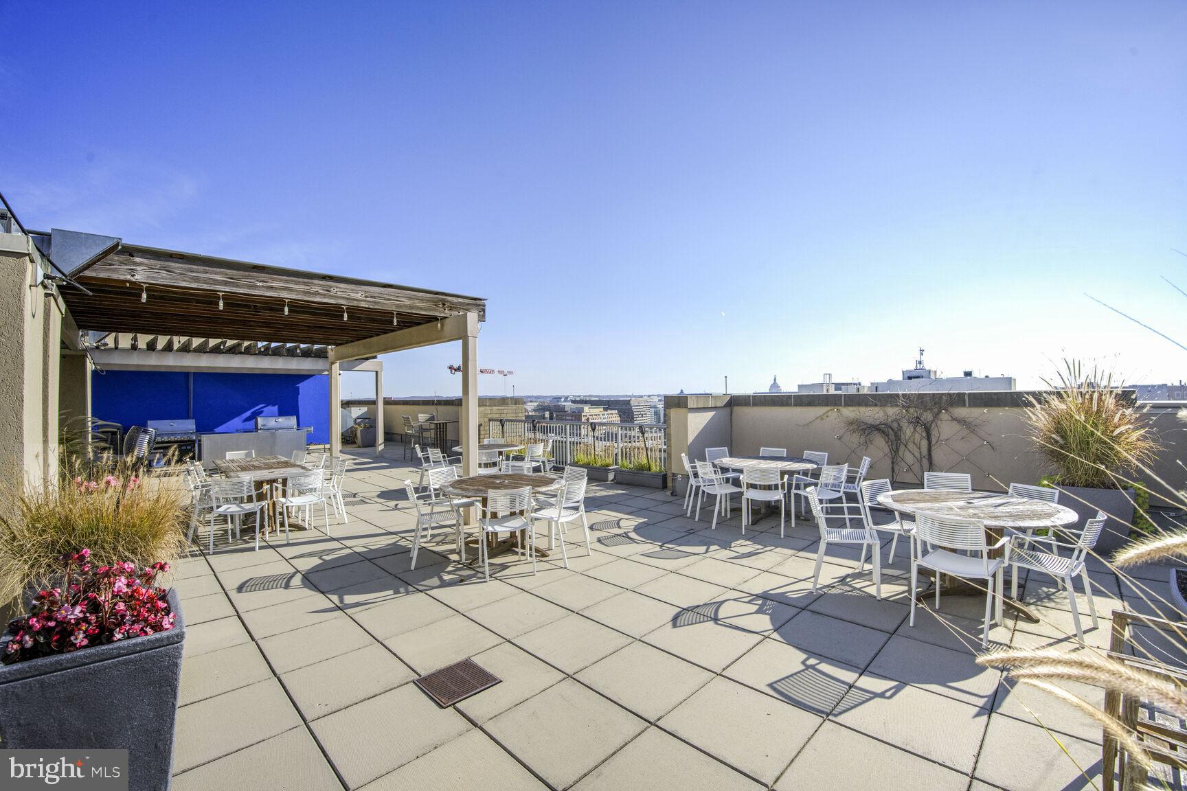 811 4th Street Northwest, Unit 807 Washington, DC 20001 - Photo 24 of 32 a roof deck with table and chairs a barbeque