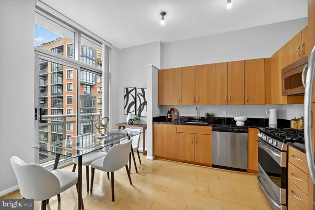 a kitchen with granite countertop a stove a sink and a microwave