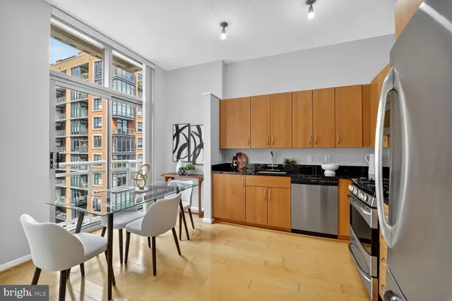 a kitchen with stainless steel appliances granite countertop a stove top oven a sink and a refrigerator