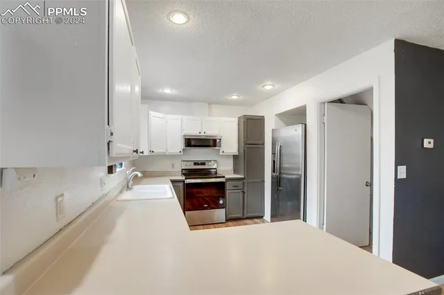 a large kitchen with a large window and stainless steel appliances