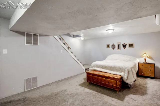 a spacious bedroom with a bed and a night stand