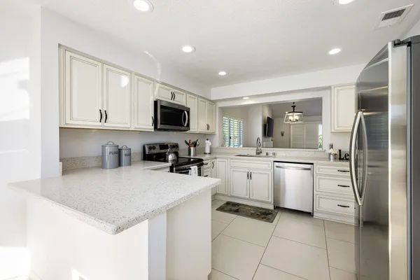 a kitchen with a sink a counter top space cabinets and stainless steel appliances