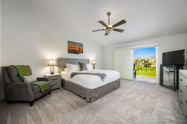 a spacious bedroom with a bed and a chandelier