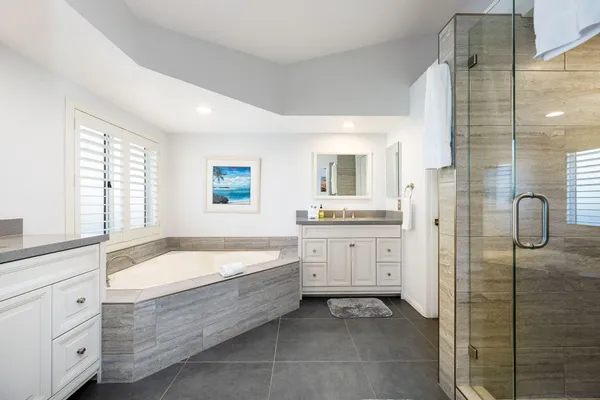 a spacious bathroom with a tub sink and mirror