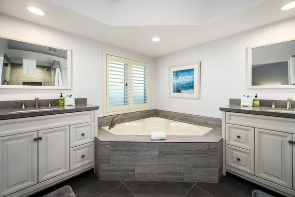 a spacious bathroom with bathtub sink and mirror