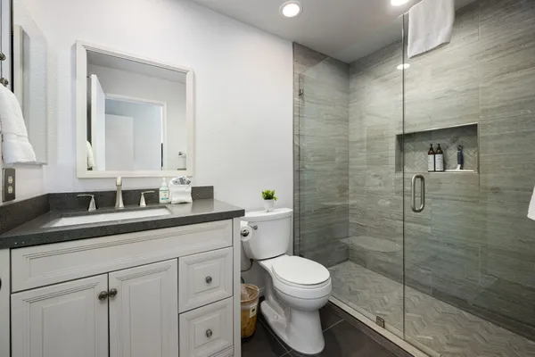 a bathroom with a sink a toilet and shower