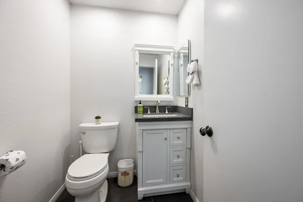 a bathroom with a toilet a sink and mirror