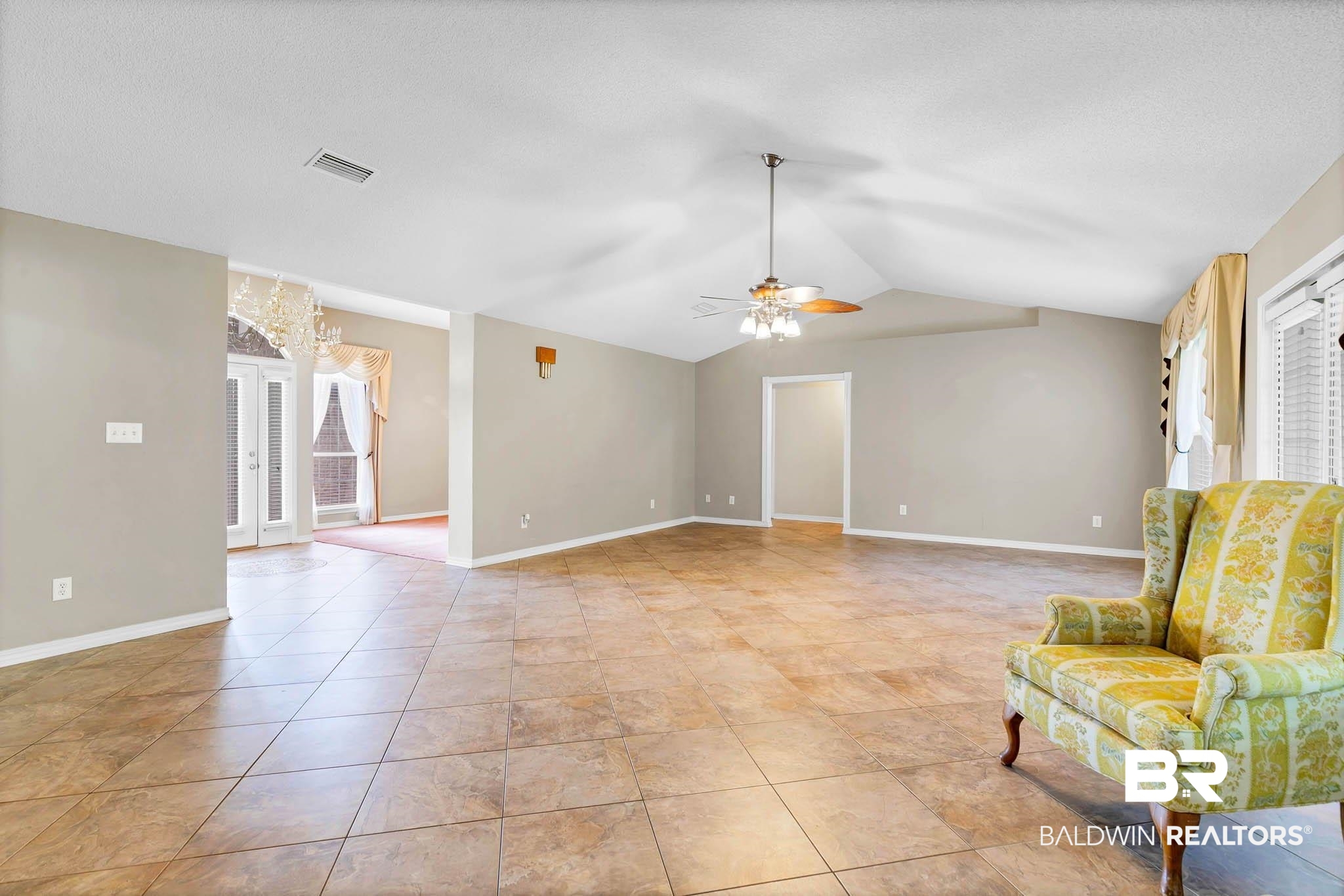 329 Collinwood Loop Foley, AL 36535 - Photo 6 of 35 Unfurnished room with a ceiling fan, lofted ceiling, a chandelier, baseboards, and light tile patterned flooring