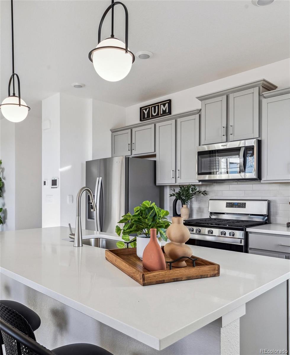 932 Logan Peak Way Berthoud, CO 80513 - Photo 12 of 34 a kitchen with stainless steel appliances a sink a refrigerator and a stove