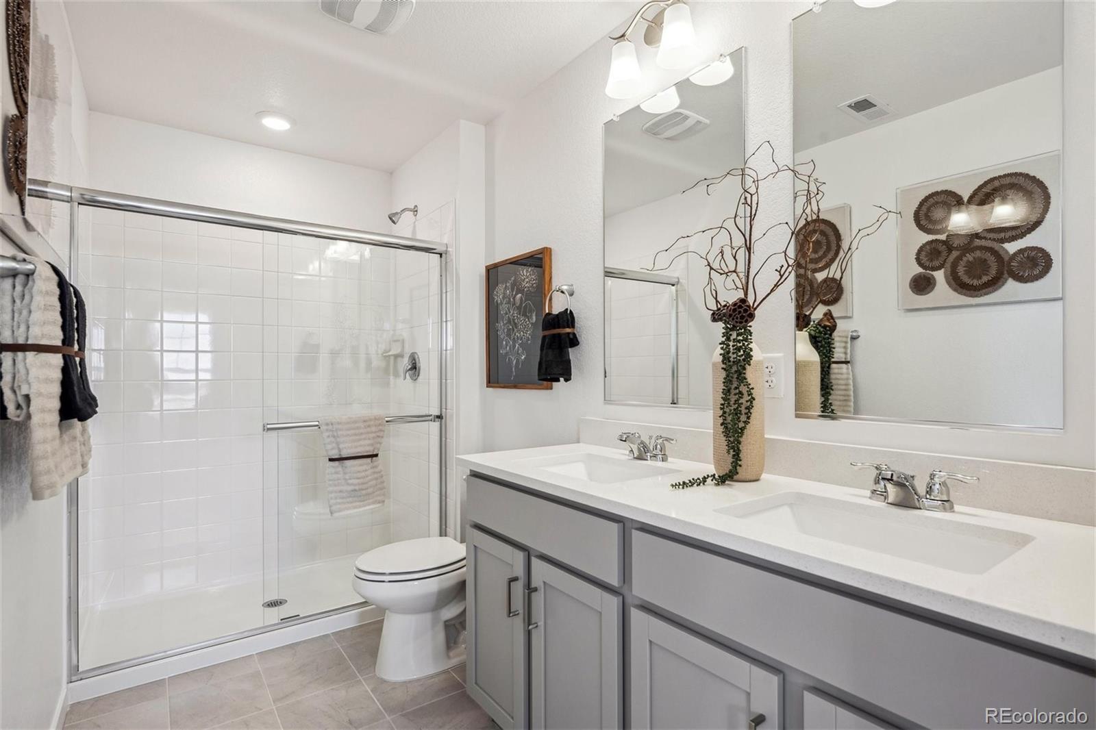 932 Logan Peak Way Berthoud, CO 80513 - Photo 22 of 34 a bathroom with a granite countertop sink a toilet and shower