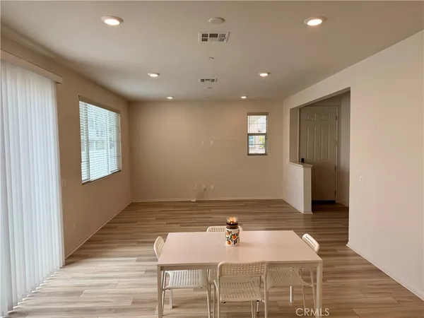 a view of an empty room with a window and a kitchen