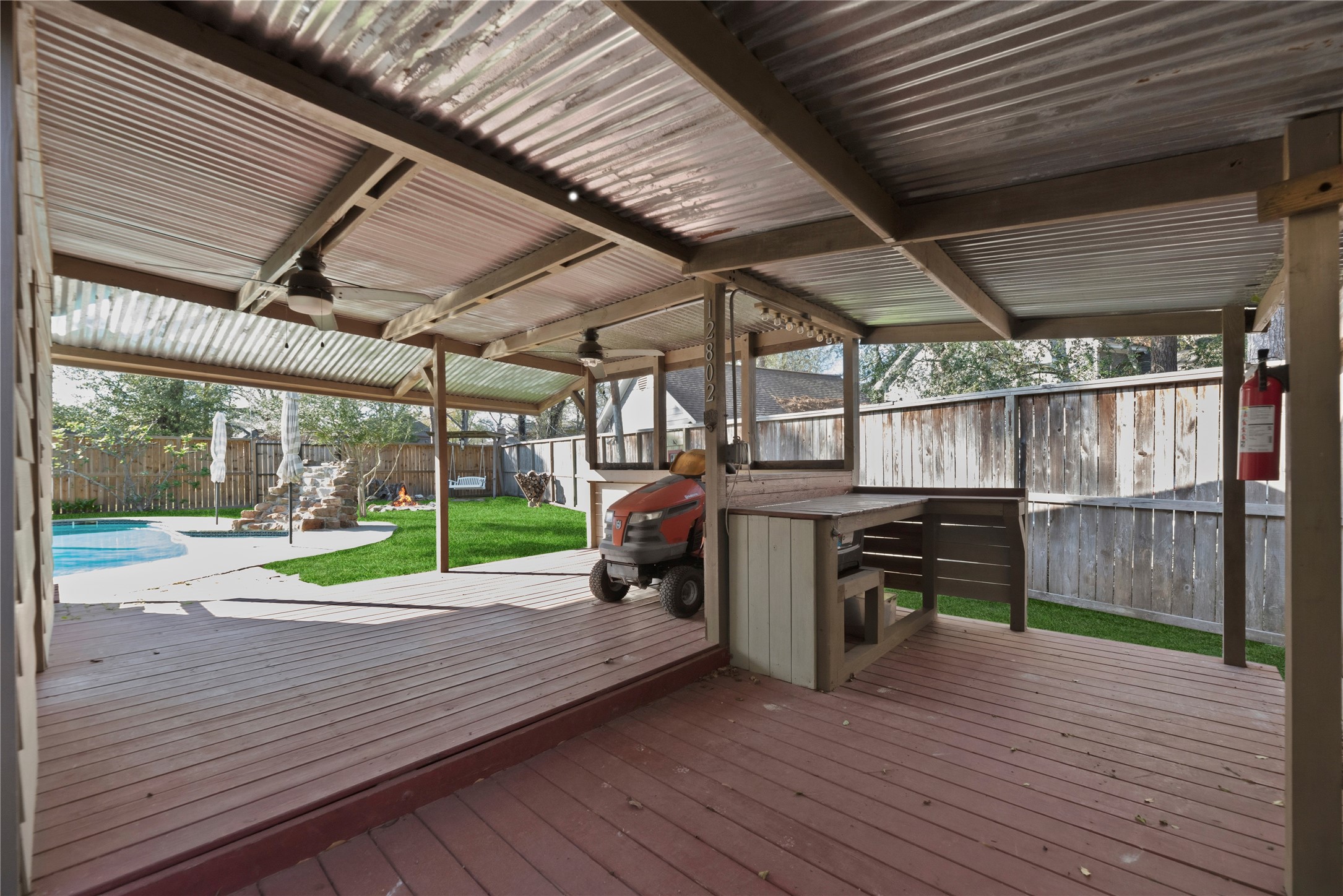 12802 Jarvis Road Cypress, TX 77429 - Photo 24 of 29 a view of a deck with wooden floor and roof with a barbeque grill