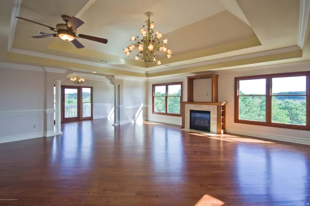 a view of an entryway with wooden floor a ceiling fan and windows