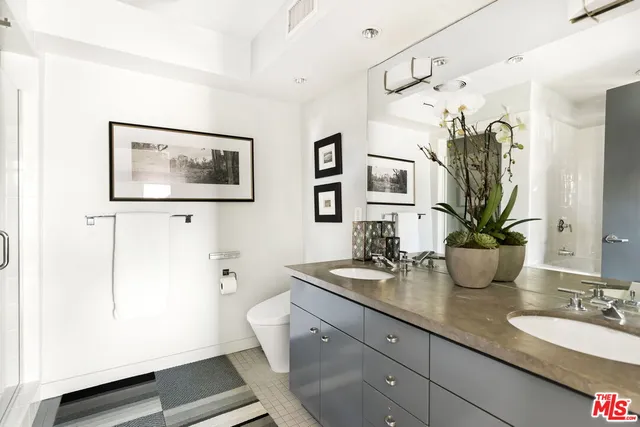 a bathroom with a granite countertop sink a toilet and mirror