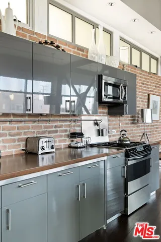 a kitchen with stainless steel appliances granite countertop a sink a stove and a microwave