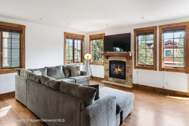 a living room with furniture a flat screen tv and a fireplace