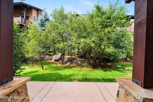 a view of a house with a yard and potted plants