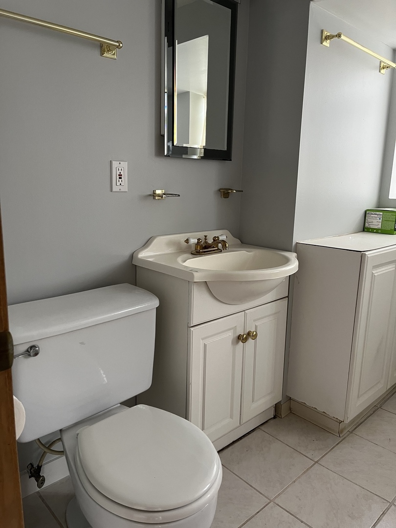 393 Herrick Road Riverside, IL 60546 - Photo 23 of 36 a white toilet sitting next to a bathroom sink