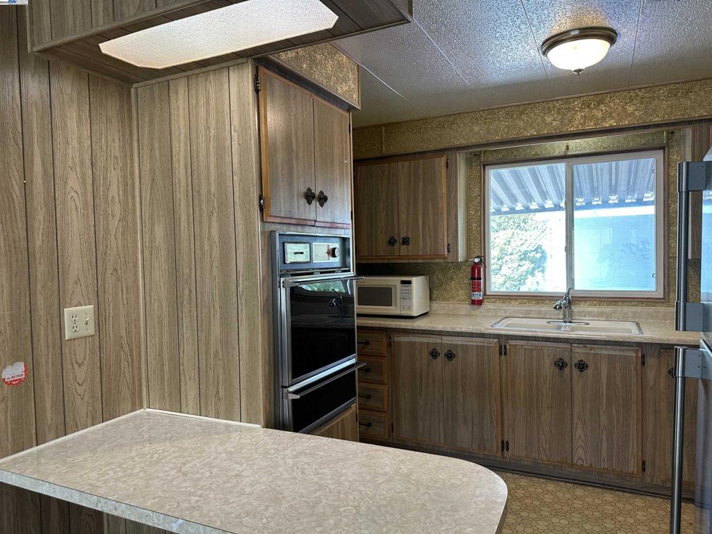 711 Old Canyon Road Fremont, CA 94538 - Photo 13 of 39 a kitchen with stainless steel appliances granite countertop a refrigerator sink and cabinets