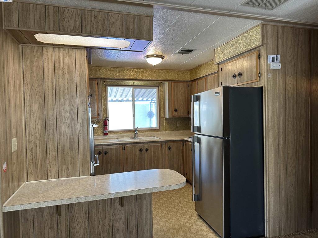 711 Old Canyon Road Fremont, CA 94538 - Photo 15 of 39 a kitchen with a refrigerator a sink and cabinets