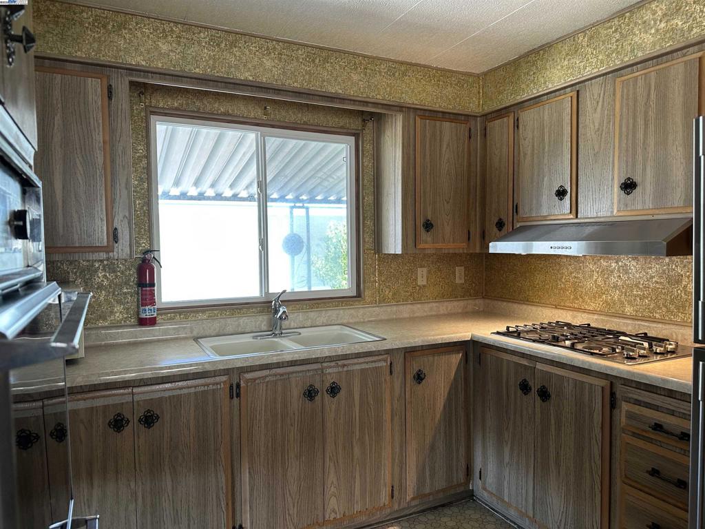 711 Old Canyon Road Fremont, CA 94538 - Photo 16 of 39 a kitchen with granite countertop a sink a stove and cabinets