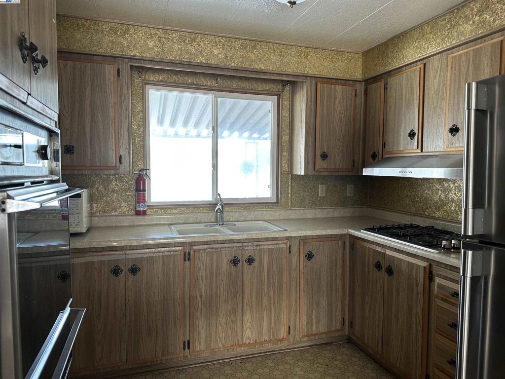 711 Old Canyon Road Fremont, CA 94538 - Photo 17 of 39 a kitchen with a sink stove and cabinets