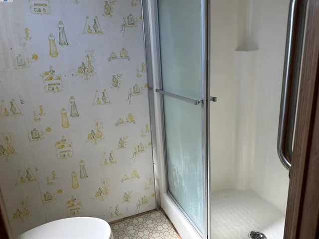 a bathroom with a toilet and a shower