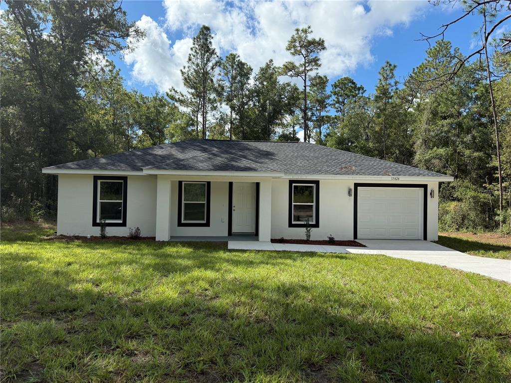 15424 Southwest 27th Lane Ocala, FL 34481 - Photo 1 of 21 a front view of house with yard and trees in the background