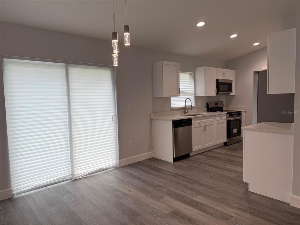 15424 Southwest 27th Lane Ocala, FL 34481 - Photo 14 of 21 a kitchen with stainless steel appliances granite countertop a sink cabinets and wooden floor