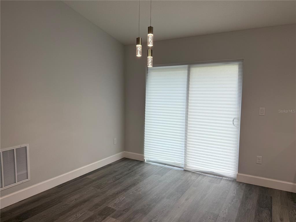15424 Southwest 27th Lane Ocala, FL 34481 - Photo 20 of 21 an empty room with wooden floor and white walls