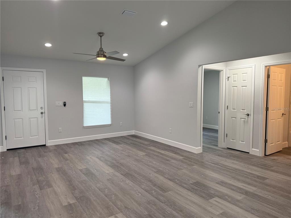 15424 Southwest 27th Lane Ocala, FL 34481 - Photo 6 of 21 an empty room with wooden floor chandelier and windows