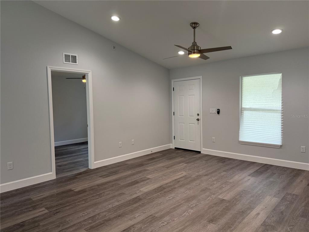 15424 Southwest 27th Lane Ocala, FL 34481 - Photo 7 of 21 an empty room with wooden floor ceiling fan and window
