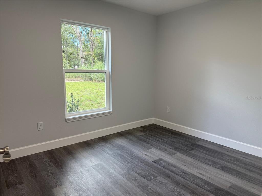 15424 Southwest 27th Lane Ocala, FL 34481 - Photo 8 of 21 an empty room with wooden floor and windows