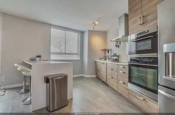 a kitchen with stainless steel appliances kitchen island granite countertop a refrigerator and cabinets