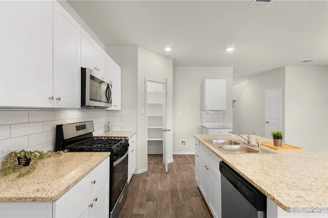 a kitchen with a sink stove top oven and refrigerator