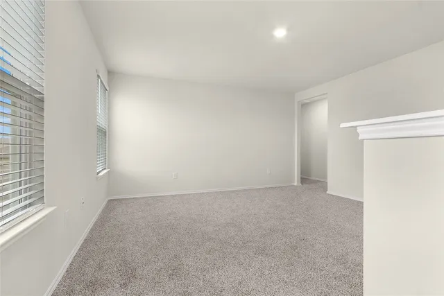 an empty room with windows and entrance to other room