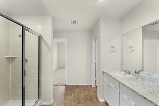 a bathroom with a granite countertop sink mirror and shower