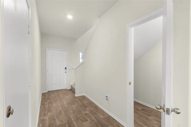 an empty room with wooden floor and shower