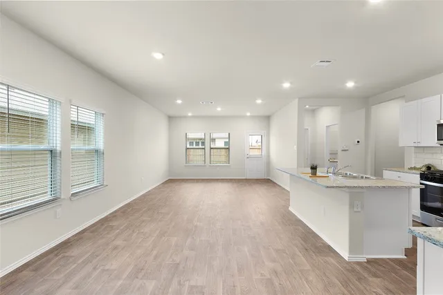 a view of kitchen with kitchen island wooden floor center island and stainless steel appliances with wooden floor