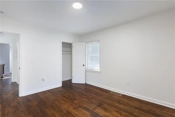 a view of an empty room with wooden floor