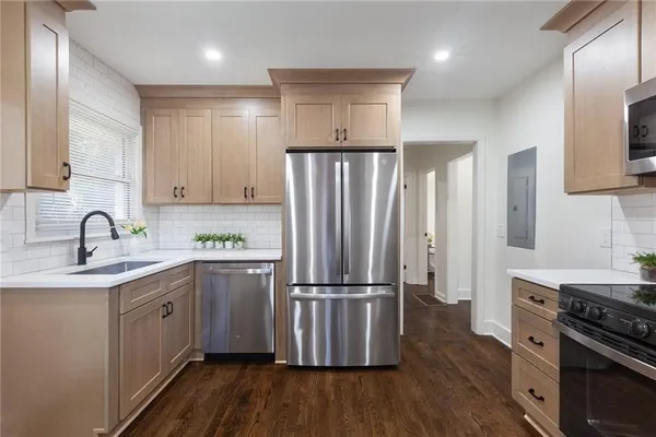 a kitchen with wooden floors and stainless steel appliances