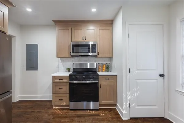 a kitchen with kitchen island granite countertop a stove and a refrigerator